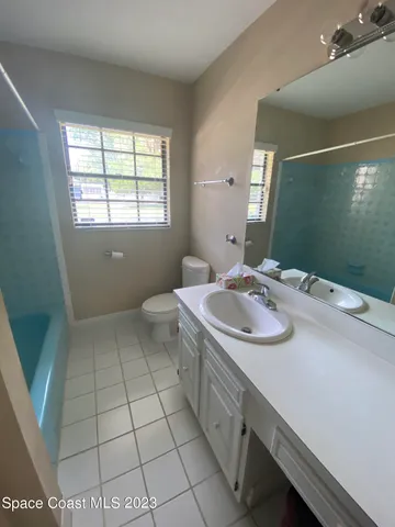 a bathroom with a sink a toilet and mirror