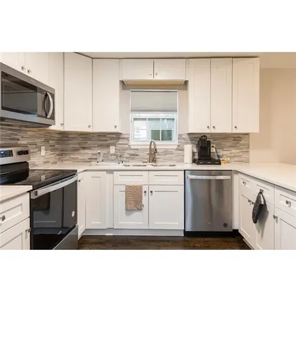 a kitchen with stainless steel appliances a sink stove and microwave