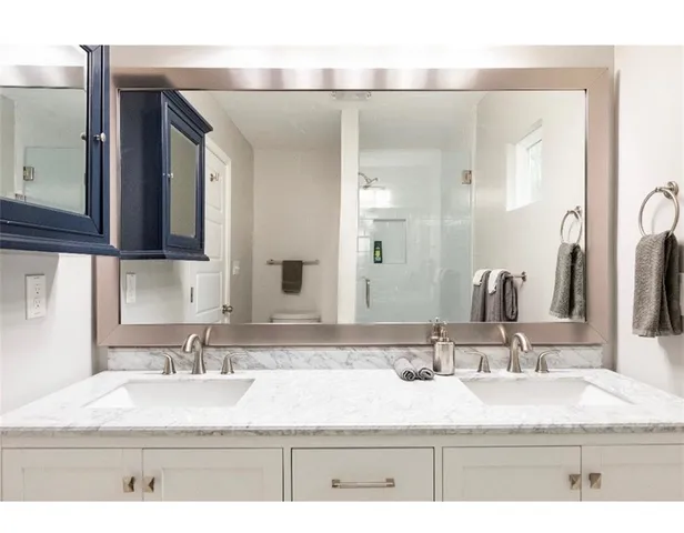 a bathroom with a sink vanity granite and a mirror