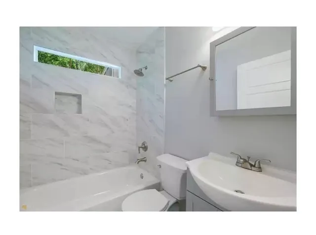 a bathroom with a sink a toilet and bathtub