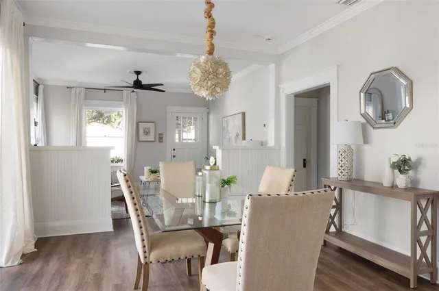 a dining room with furniture a chandelier and wooden floor