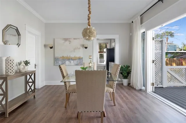 a dining room with furniture a chandelier and wooden floor