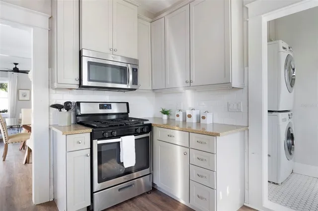 a kitchen with stainless steel appliances white cabinets white stove a sink and dishwasher
