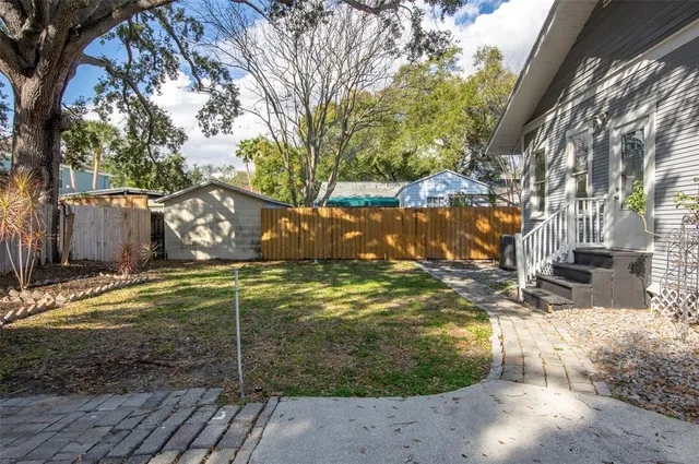 a view of a yard with wooden fence