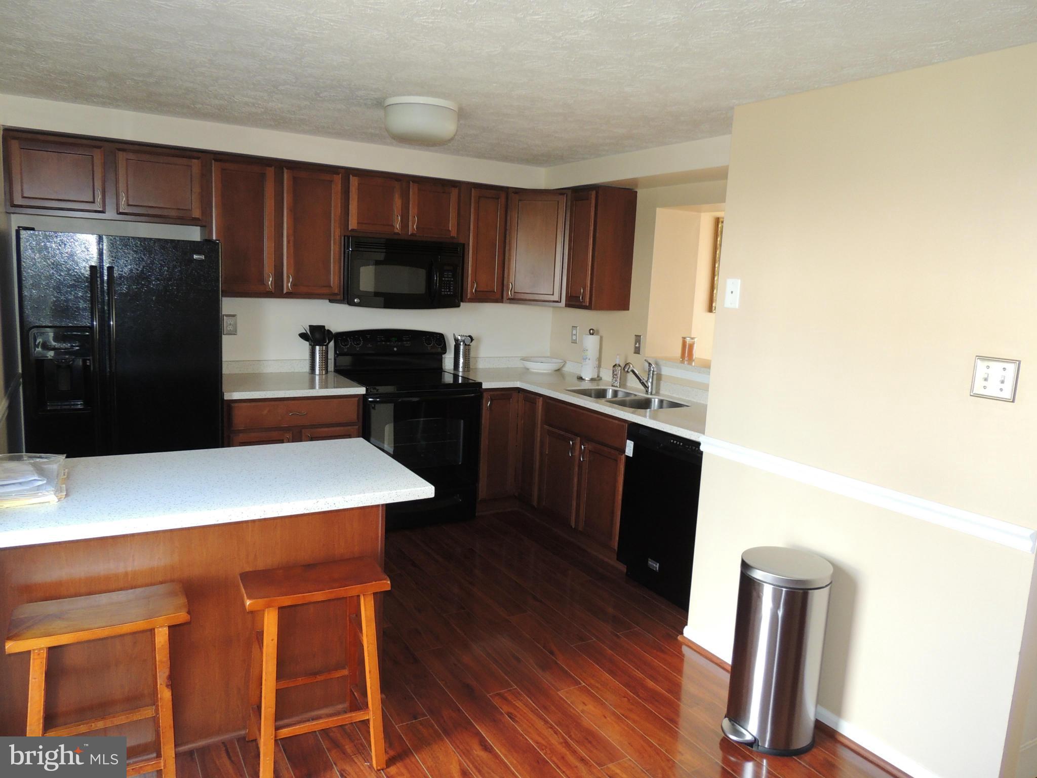 8 Hyacinth Road Baltimore, MD 21234 - Photo 3 of 21 a kitchen with a sink a stove a refrigerator and black cabinets