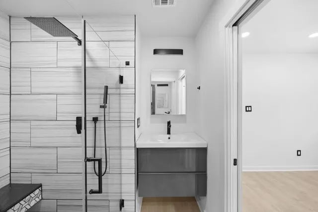 a bathroom with a shower sink and mirror