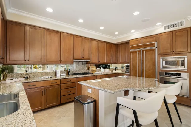 a kitchen with a sink a counter top space cabinets and stainless steel appliances
