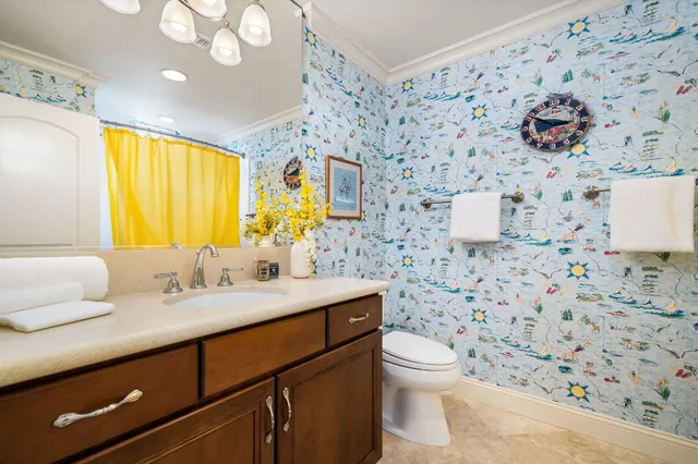 a bathroom with a granite countertop sink mirror vanity and toilet