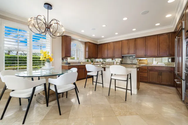 a kitchen with a dining table chairs sink and stove