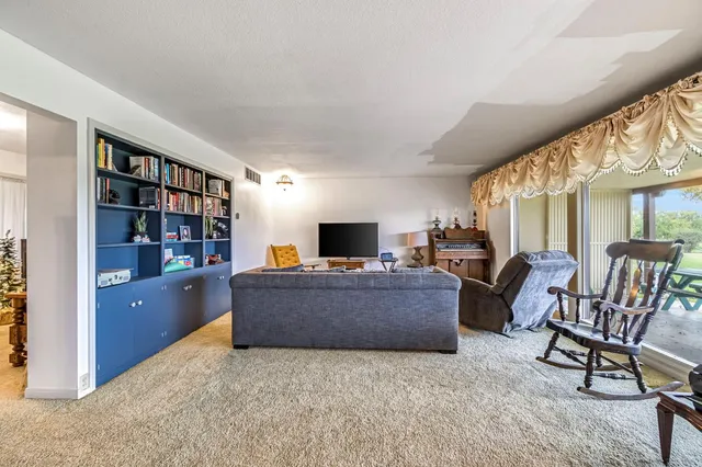 a living room with furniture and a book shelf