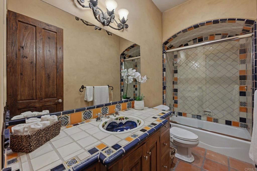 3244 Olivenhain Farms Road Encinitas, CA 92024 - Photo 32 of 47 a bathroom with a sink a toilet and shower curtain