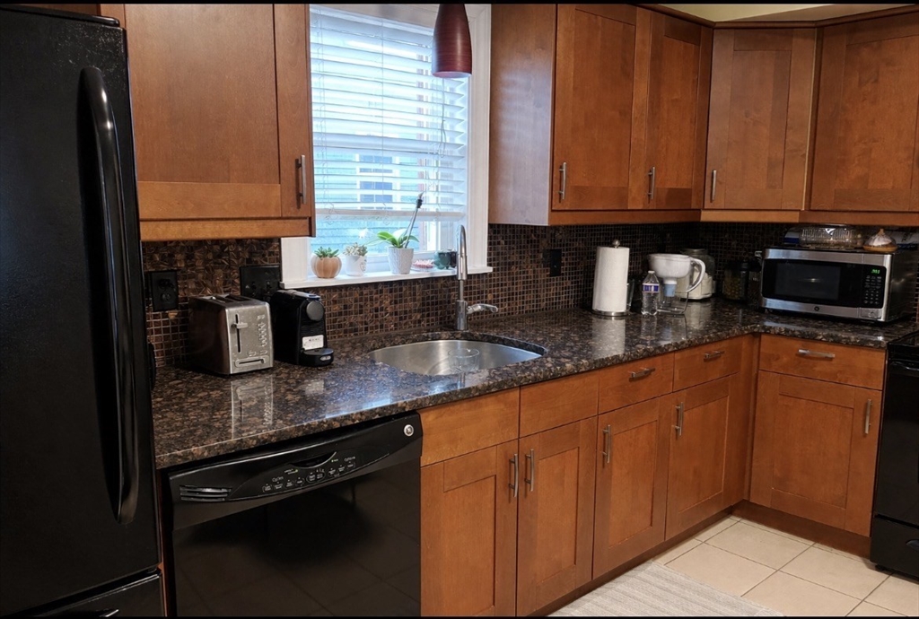 17 Proctor Street Peabody, MA 01960 - Photo 5 of 13 a kitchen with stainless steel appliances granite countertop a sink stove and cabinets
