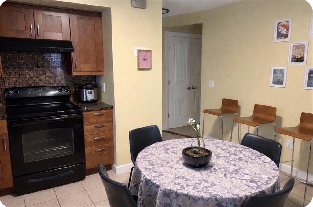 17 Proctor Street Peabody, MA 01960 - Photo 6 of 13 a kitchen with a stove and a wooden cabinets