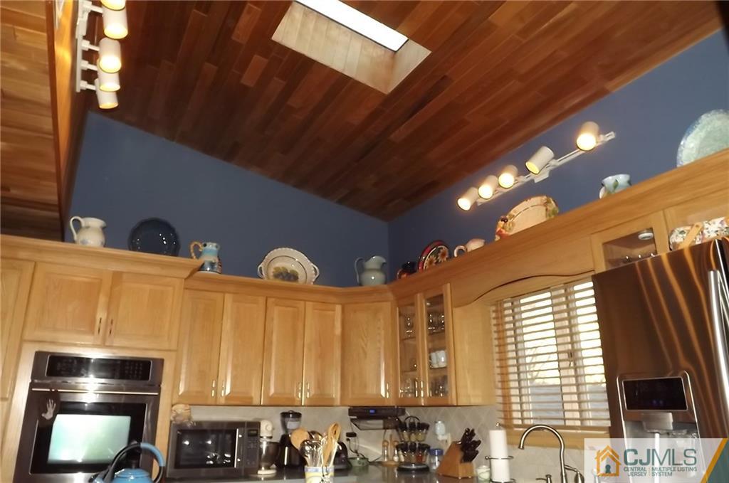 93 Magnolia Road Iselin, NJ 08830 - Photo 11 of 25 a kitchen with stainless steel appliances granite countertop a stove a sink and a microwave