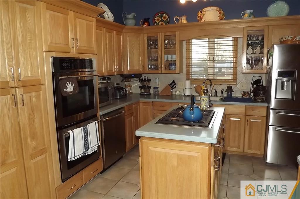 93 Magnolia Road Iselin, NJ 08830 - Photo 12 of 25 a kitchen with stainless steel appliances granite countertop a refrigerator a sink a stove and a microwave