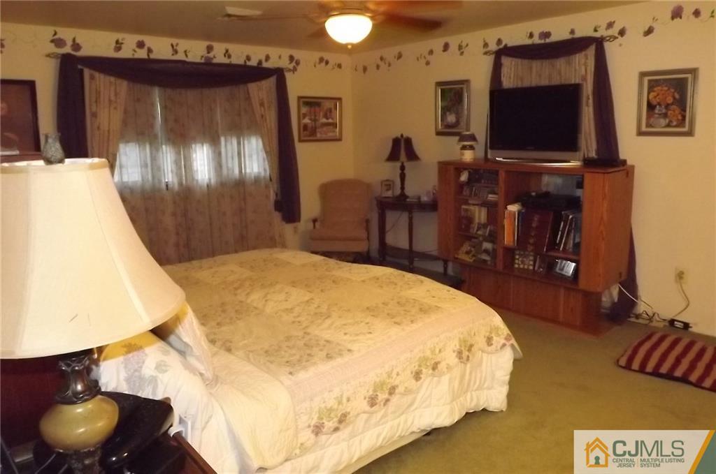 93 Magnolia Road Iselin, NJ 08830 - Photo 15 of 25 a bedroom with a bed and a flat screen tv