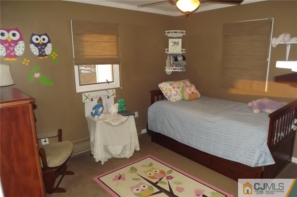 93 Magnolia Road Iselin, NJ 08830 - Photo 21 of 25 a bedroom with a bed and chandelier