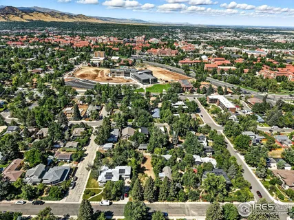 an aerial view of residential houses with outdoor space and trees