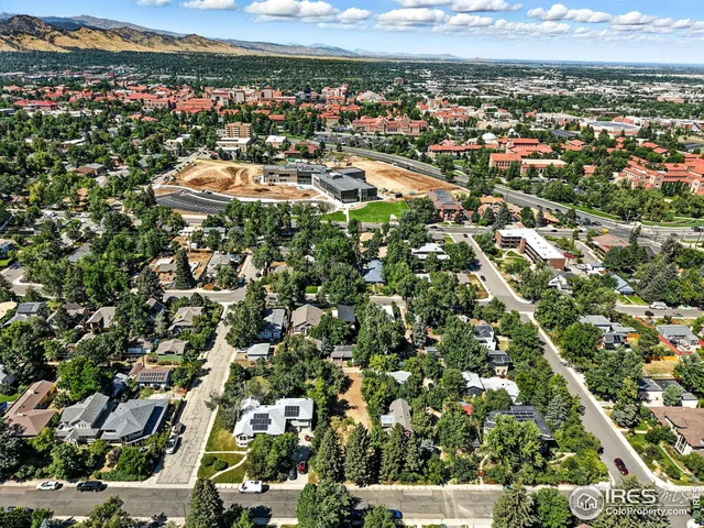 an aerial view of residential houses with outdoor space and trees