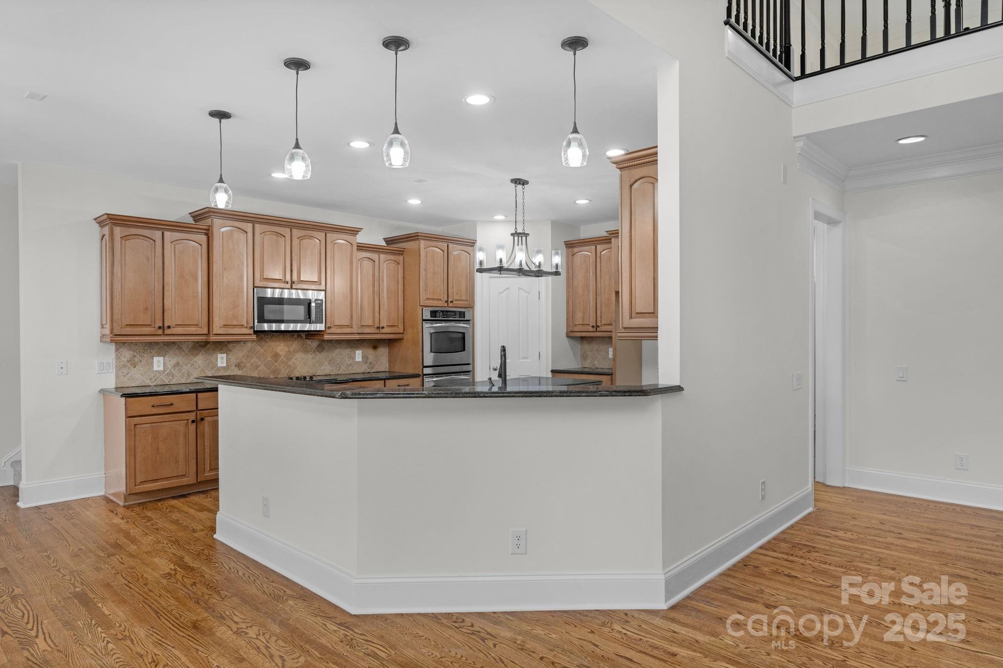 1300 Longleaf Court Weddington, NC 28104 - Photo 13 of 48 a large kitchen with granite countertop a large counter top a sink stainless steel appliances and cabinets