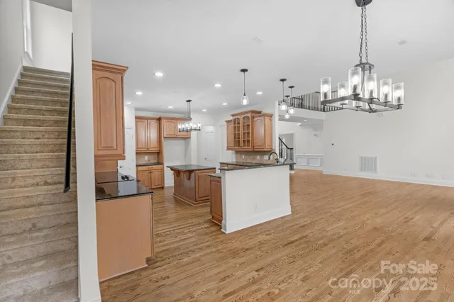 a kitchen with stainless steel appliances kitchen island granite countertop a table and chairs in it