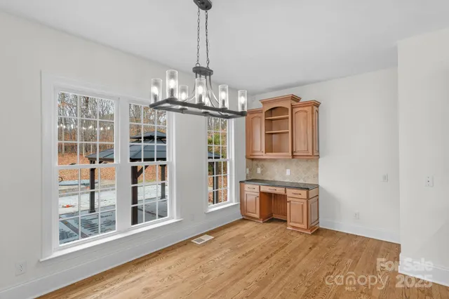 a view of a big room with windows and chandelier