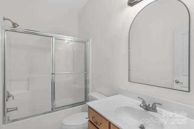 an empty room with windows and ceiling fan