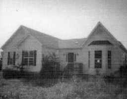 a view of a brick house next to a yard