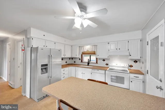 a kitchen with stainless steel appliances a stove refrigerator sink and cabinets