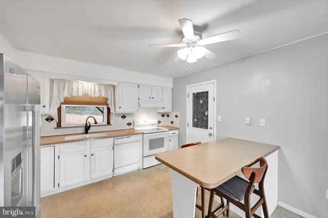 a kitchen with a table chairs sink and cabinets