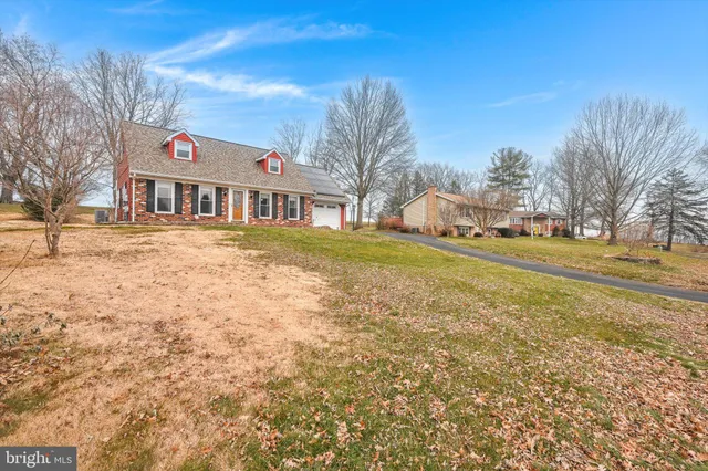 a front view of residential houses with yard and trees