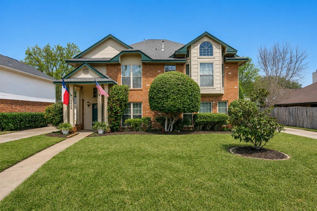Two-story brick facade residence featuring a prominent bay window with an arched transom