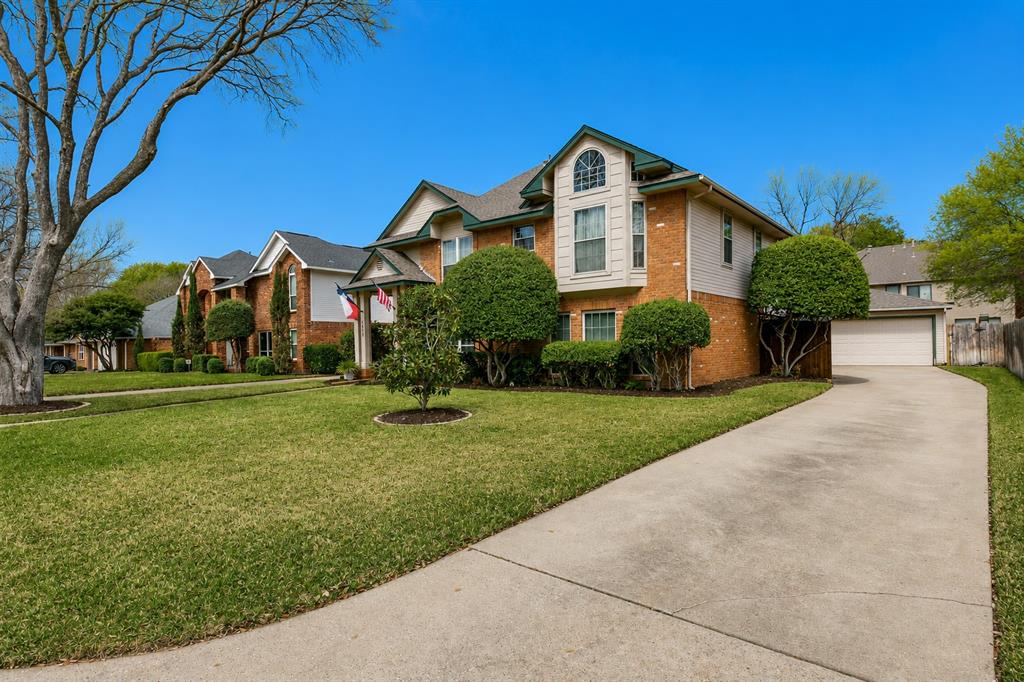 3438 Spring Willow Drive Grapevine, TX 76051 - Photo 2 of 23 Brick and siding exterior featuring an arched window, a gabled roofline, a concrete driveway, and mature landscaping