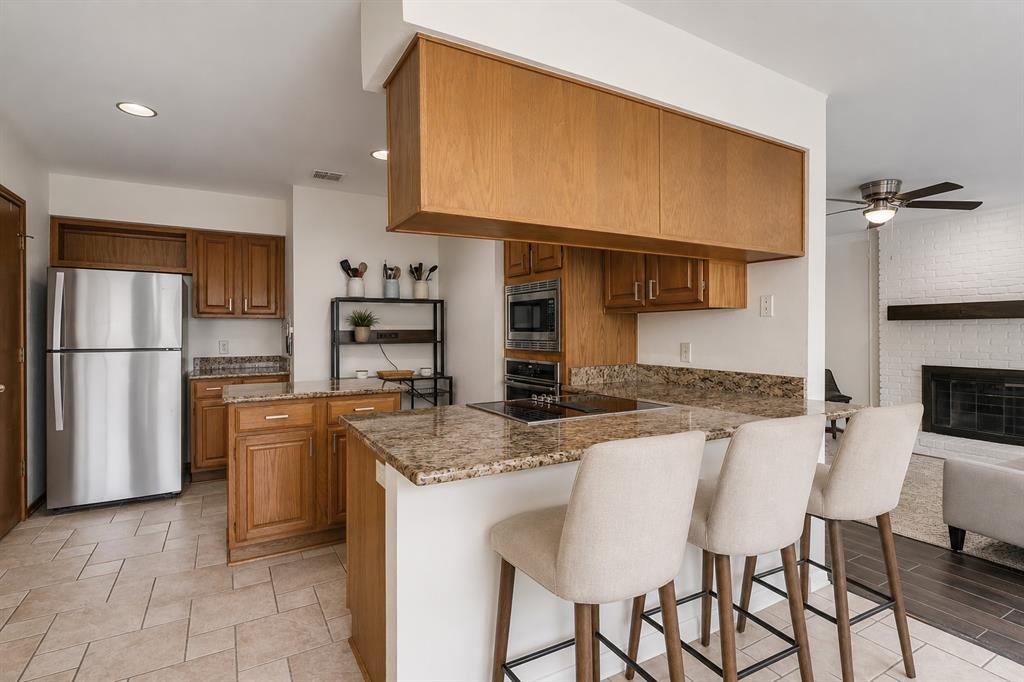 3438 Spring Willow Drive Grapevine, TX 76051 - Photo 6 of 23 Virtual Staging. Kitchen featuring wood cabinetry, granite countertops, stainless steel appliances, and a cooktop on the island