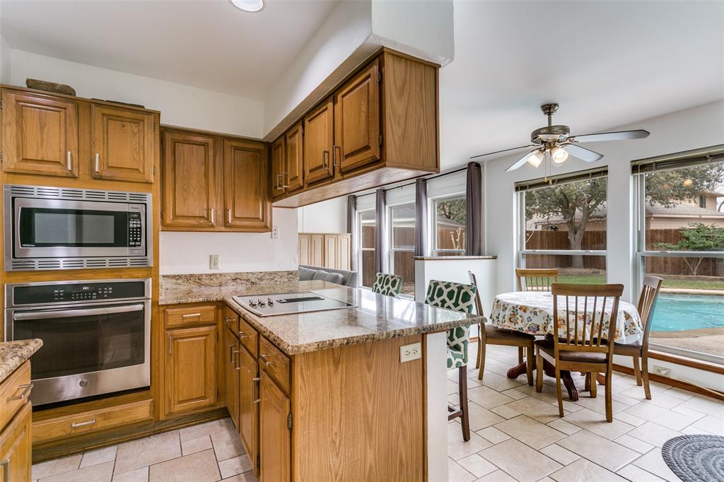 3438 Spring Willow Drive Grapevine, TX 76051 - Photo 8 of 27 a kitchen with granite countertop stove top oven dining table and chairs
