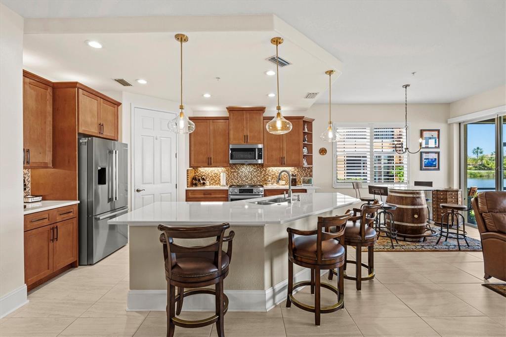 1135 Riverscape Street, Unit 1135 Bradenton, FL 34208 - Photo 11 of 100 a kitchen with stainless steel appliances kitchen island granite countertop a table chairs and a refrigerator