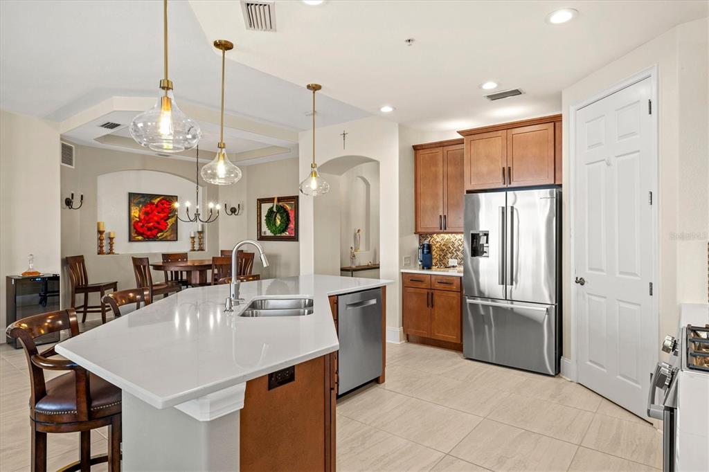 1135 Riverscape Street, Unit 1135 Bradenton, FL 34208 - Photo 14 of 100 a kitchen with stainless steel appliances granite countertop a refrigerator a sink dishwasher a oven and a dining table with wooden floor