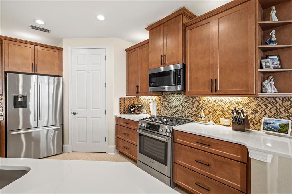 1135 Riverscape Street, Unit 1135 Bradenton, FL 34208 - Photo 15 of 100 a kitchen with stainless steel appliances a refrigerator sink and microwave
