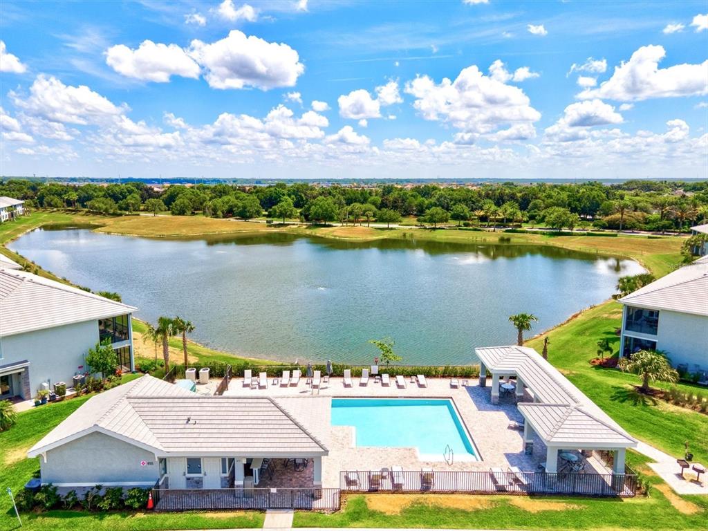 1135 Riverscape Street, Unit 1135 Bradenton, FL 34208 - Photo 77 of 100 a view of a city with swimming pool and mountains in the background