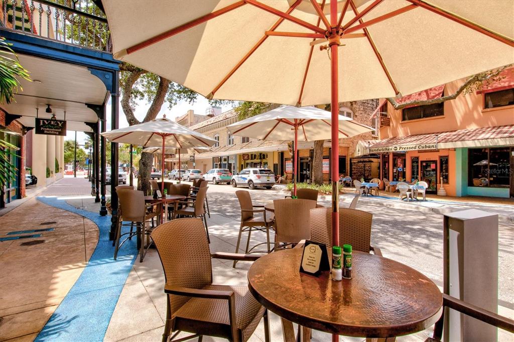 1135 Riverscape Street, Unit 1135 Bradenton, FL 34208 - Photo 91 of 100 a view of a patio with dining table and chairs under an umbrella