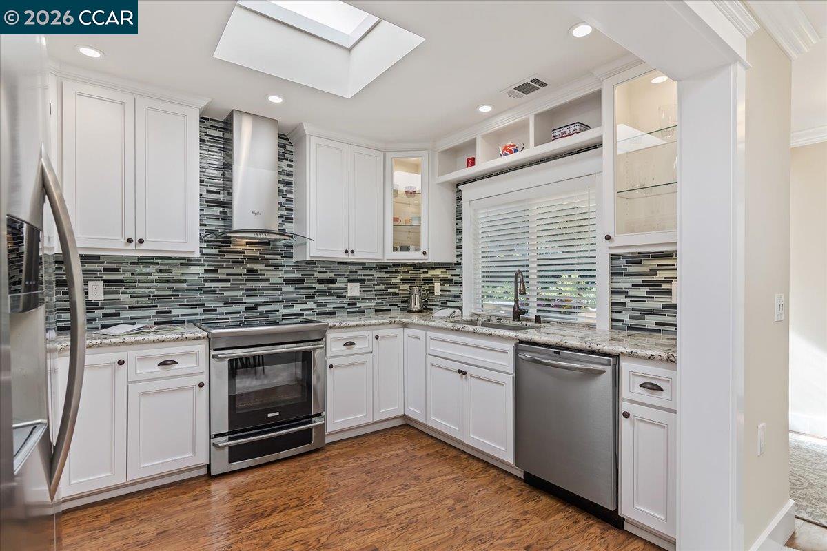 1332 Running Springs Road, Unit 1 Walnut Creek, CA 94595 - Photo 8 of 26 a kitchen with stainless steel appliances granite countertop a sink cabinets and wooden floor