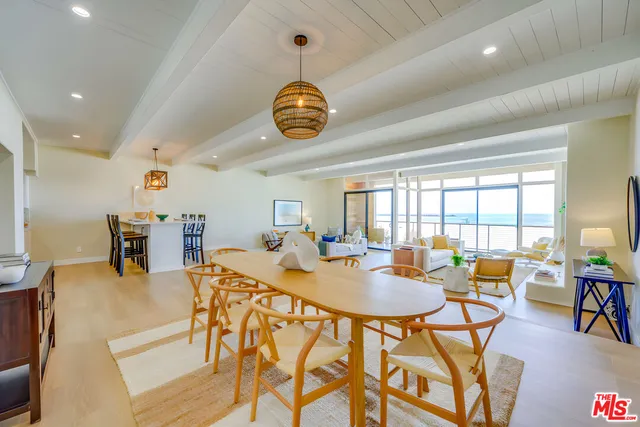 a view of a dining room and livingroom with furniture wooden floor and a large window
