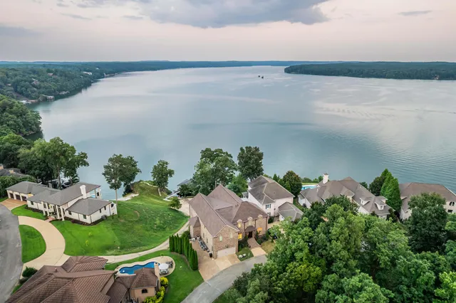 an aerial view of a house with a yard and lake view