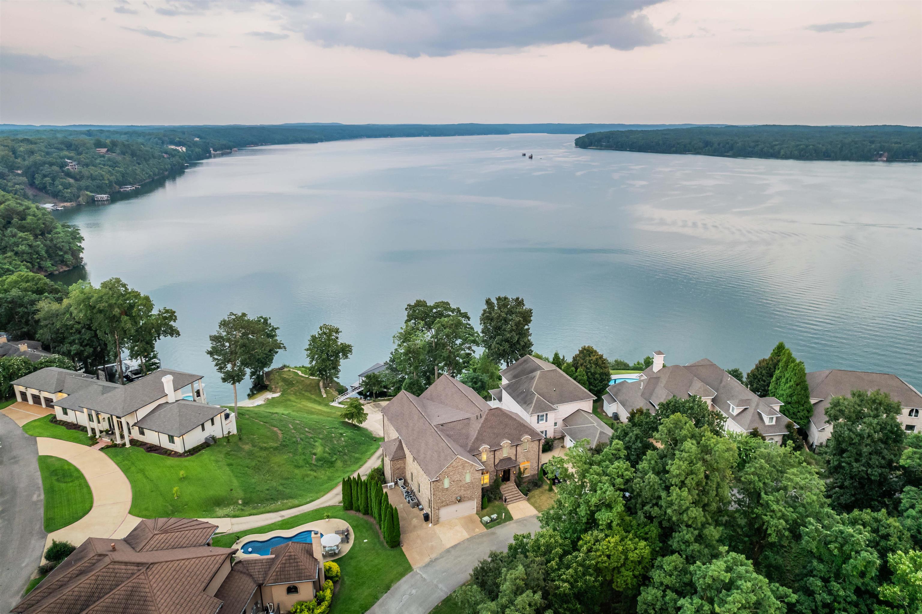an aerial view of a house with a yard and lake view