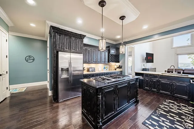 a kitchen with stainless steel appliances granite countertop a stove a refrigerator and a wooden floors