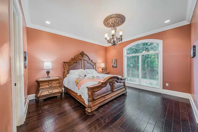 a bedroom with a bed chandelier and window