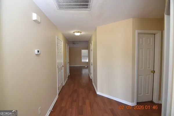 a view of a hallway with wooden floor