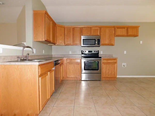 a kitchen with stainless steel appliances granite countertop a stove a sink and a microwave
