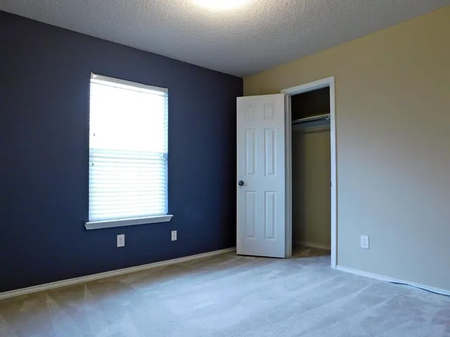 an empty room with windows and closet