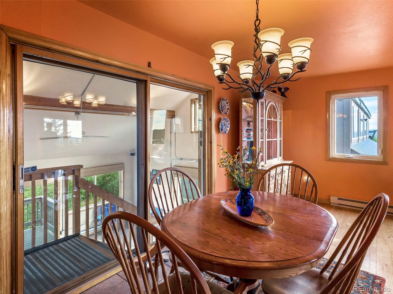 40705 Hill N Dale Road Steamboat Springs, CO 80487 - Photo 22 of 37 a view of a dining room with furniture a chandelier and large windows